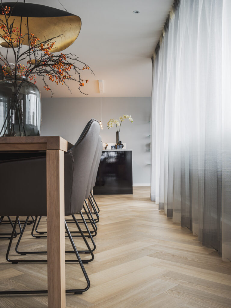 gouden lamp boven de eettafel met op de vloer een pvc visgraat van Therdex